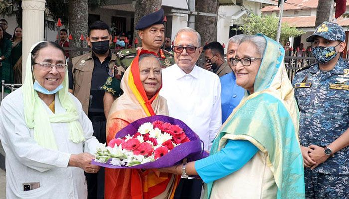 প্রধানমন্ত্রী শেখ হাসিনা বাড়িতে পৌঁছালে রাষ্ট্রপতি মো. আবদুল হামিদ ও তার পরিবারের সদস্যরা ফুল দিয়ে শুভেচ্ছা জানান। ছবি: সংগৃহীত