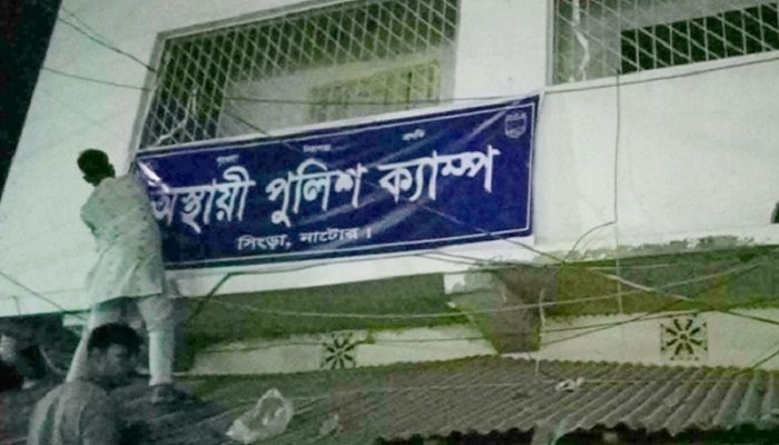 রাতের আঁধারে ব্যানার বাঁধছেন দুই যুবক। ছবি: নাটোর প্রতিনিধি