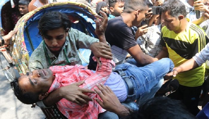 সংঘর্ষে আহত এক শ্রমিককে হাসপাতালে নেওয়া হচ্ছে। ছবি: সাম্প্রতিক দেশকাল