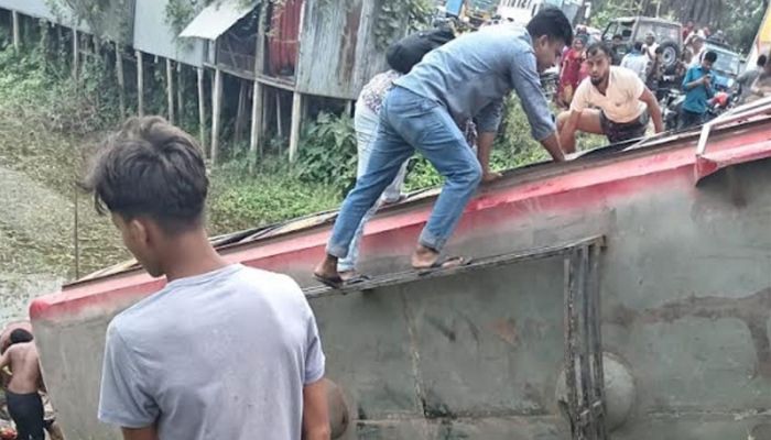 দুর্ঘটনার পর খাদে পড়ে যাওয়া বাসটি থেকে হতাহতদের উদ্ধার করছেন স্থানীয়রা। ছবি: সাম্প্রতিক দেশকাল